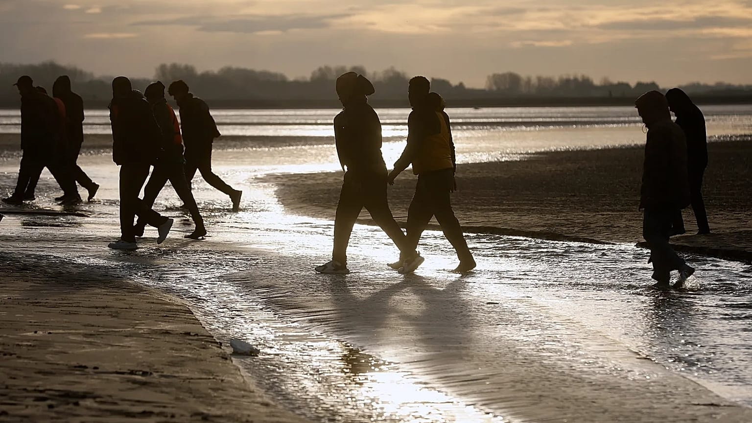 Migrants leave the beach after failing to cross the Channel and reach Britain, 6 November, 2025 