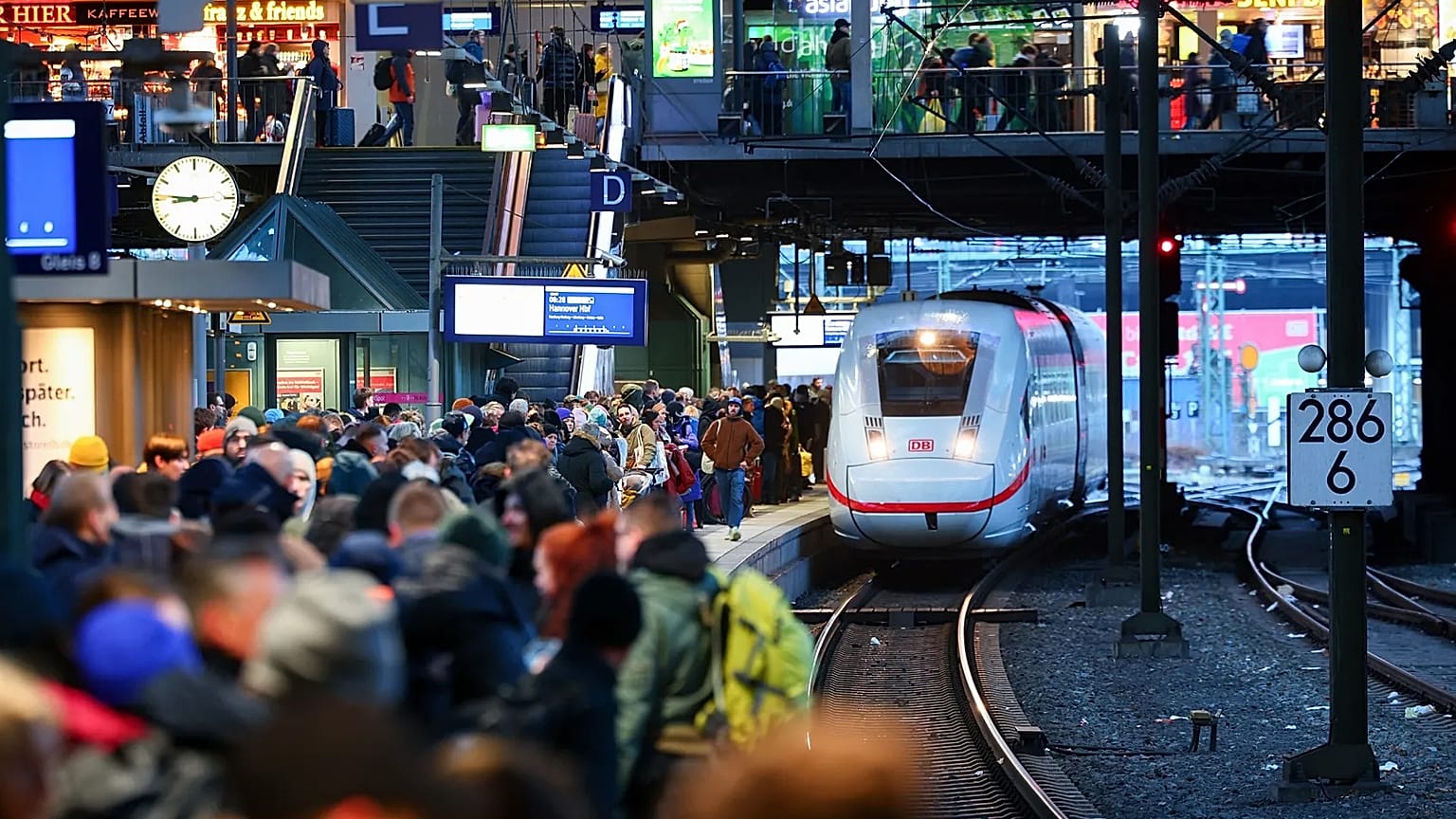 Travellers wait for their train on a full platform at the main station in Hamburg, 22 December, 2023