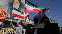 رفع المصلون الإيرانيون الأعلام الإيرانية وملصقاً للمرشد الأعلى آية الله علي خامنئي، على اليمين، أمام صورة مؤسس الثورة الراحل آية الله الخميني خلال مسيرة مناهضة لإسرائيل