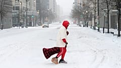 Eine Person überquert eine Straße während eines Schneesturms, Sonntag, 25. Januar 2026, in Washington.