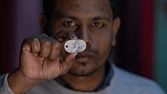 Maksudur Rahman, 31, der nach der Teilnahme an den Kämpfen entkommen konnte, zeigt sein Abzeichen der russischen Armee