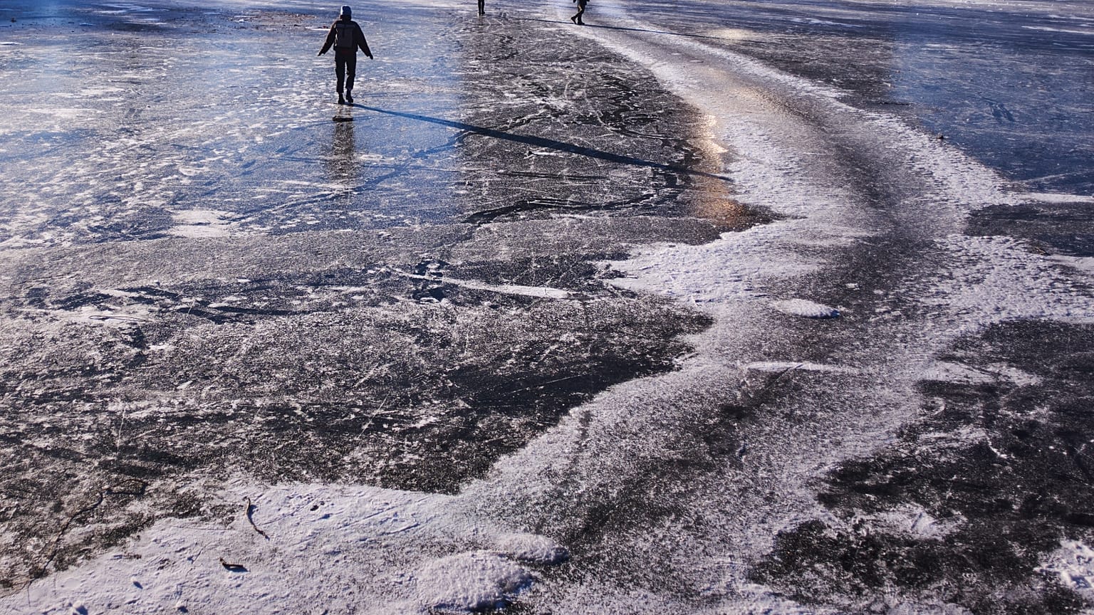 Menschen balancieren an einem kalten Wintertag in Berlin, Deutschland, am Sonntag, dem 11. Januar 2026, über den zugefrorenen Landwehrkanal.
