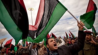 رجال ليبيون، بعضهم يرفع أعلام ليبيا ما قبل القذافي، يهتفون خلال مظاهرة للمطالبة باستقالة الزعيم الليبي معمر القذافي وفرض منطقة حظر جوي، في بنغازي شرق ليبيا