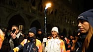 Uma portadora da tocha segura a chama olímpica em Veneza, Itália, quinta-feira, 22 de janeiro de 2026