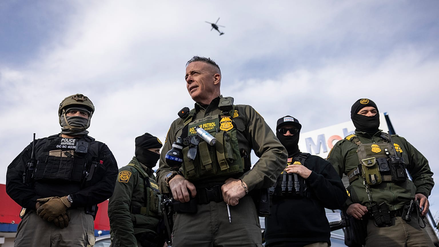 US Border Patrol Cmdr. Gregory Bovino, center, looks on after federal immigration enforcement agents detained an individual outside a Mobil gas station in Evanston