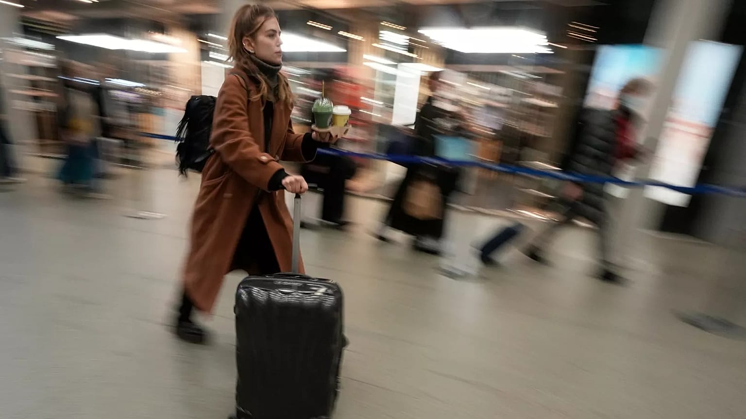 زنی در یک ایستگاه راه‌آهن در بریتانیا قدم می‌زند. عکس آرشیوی سال ۲۰۲۳.