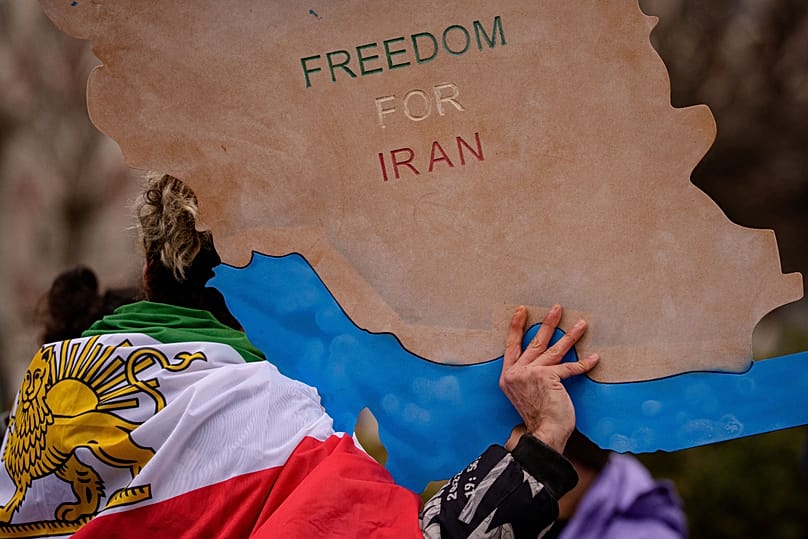 A man holds a map of Iran during a rally in support of anti-government protests in Bucharest, 24 January, 2026
