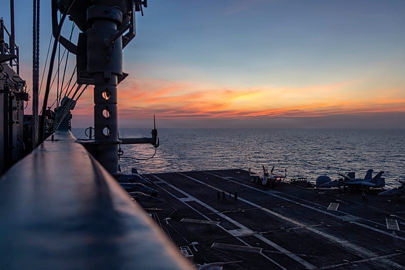 The sun sets over the USS Abraham Lincoln aircraft carrier in the Indian Ocean, 22 January, 2026