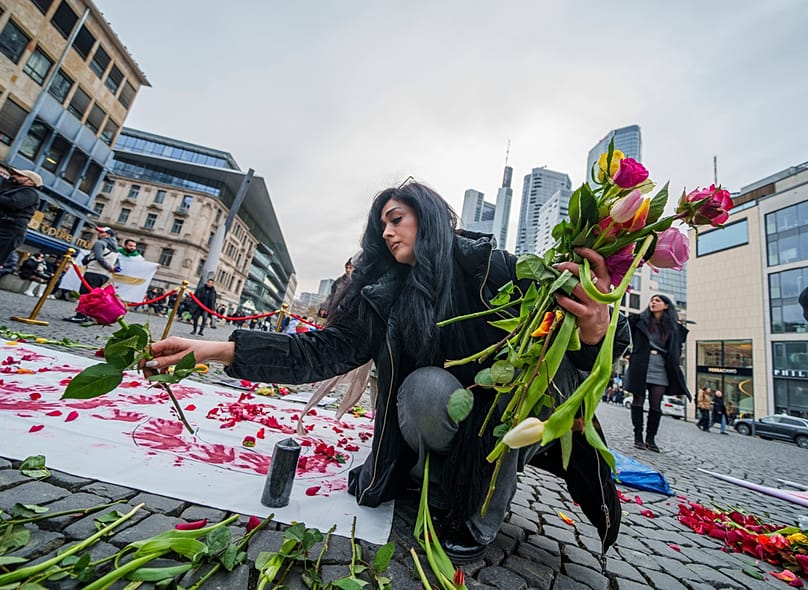 FILE: A woman places flowers on an installation during a demonstration in support of the protests happening in Iran, in Cologne, 17 January 2026