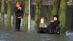 Ein Mann sitzt bei Überschwemmungen durch Sturm Chandra auf einer Bank. Dublin, Irland, 27. Januar 2026.