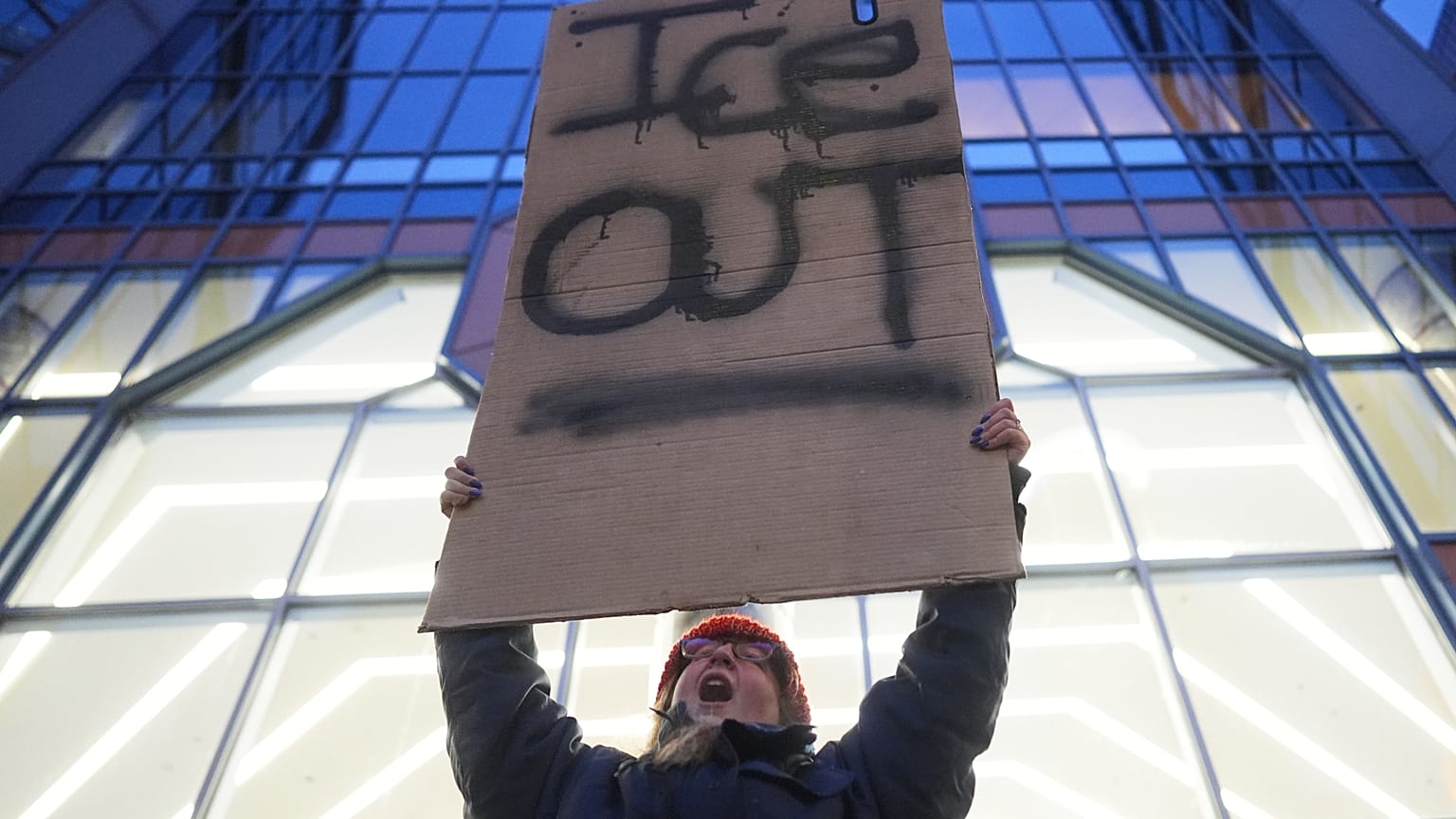 Una manifestante tiene un cartello con la scritta “Fuori l'Ice” durante una protesta a Minneapolis (26 gennaio 2026)