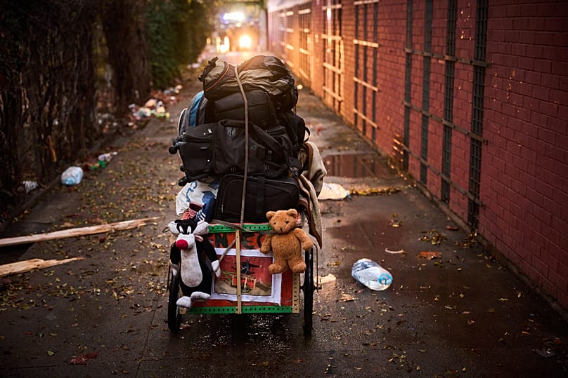 A migrant carries his belongings at an abandoned school building where hundreds of mostly undocumented migrants had been living in Badalona, 17 December, 2025