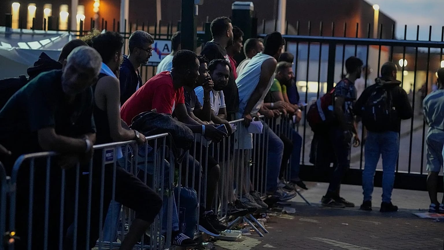 Hundreds of migrants who seek shelter prepared to spend the night outside an overcrowded asylum seekers centre in Ter Apel, 25 August, 2022