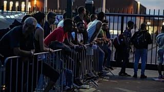 Ter Apel'de aşırı kalabalık bir sığınmacı merkezinin dışında geceyi geçirmeye hazırlanan yüzlerce göçmen, 25 Ağustos, 2022