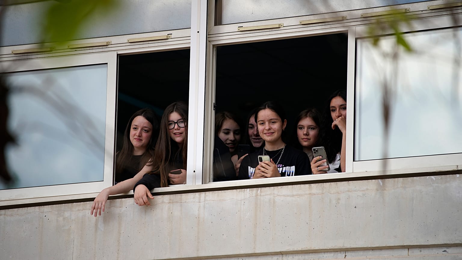 Des élèves d'un collège de Ganges, dans l'Hérault, regardent par la fenêtre le président Emmanuel Macron lors de sa visite, le jeudi 20 avril 2023.
