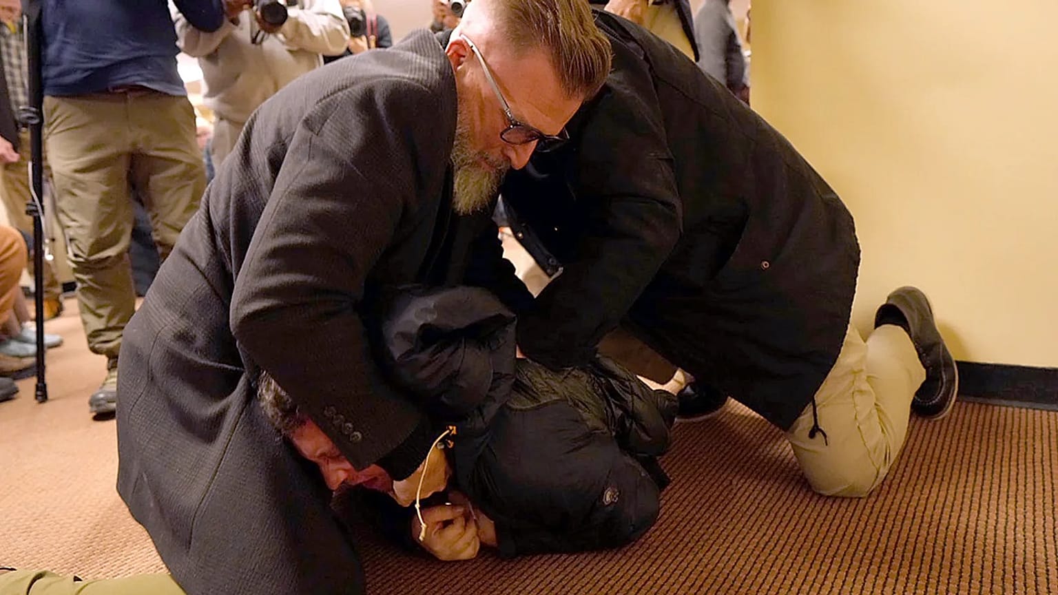 A man is tackled to the ground after spraying an unknown substance on US Congresswoman Ilhan Omar during a town hall in Minneapolis, 27 January 2026