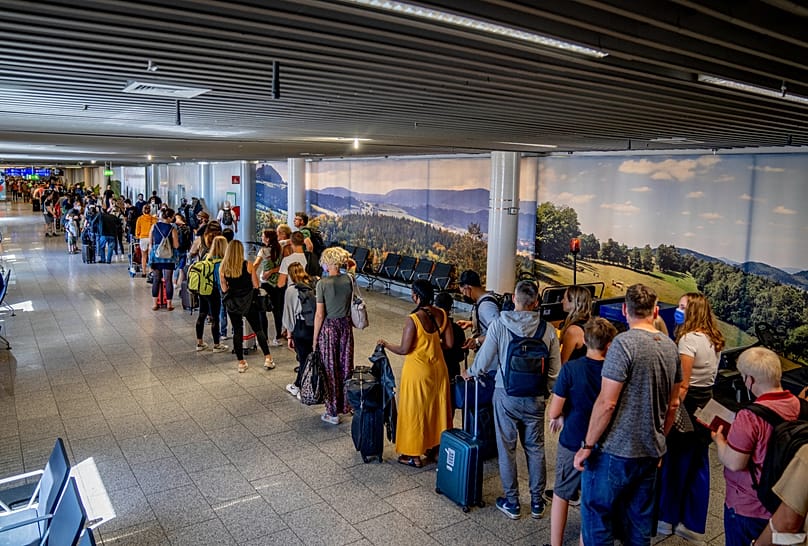 People stand in a long queue in front of the security check at the international airport in Frankfurt, Germany, Saturday, July 2, 2022