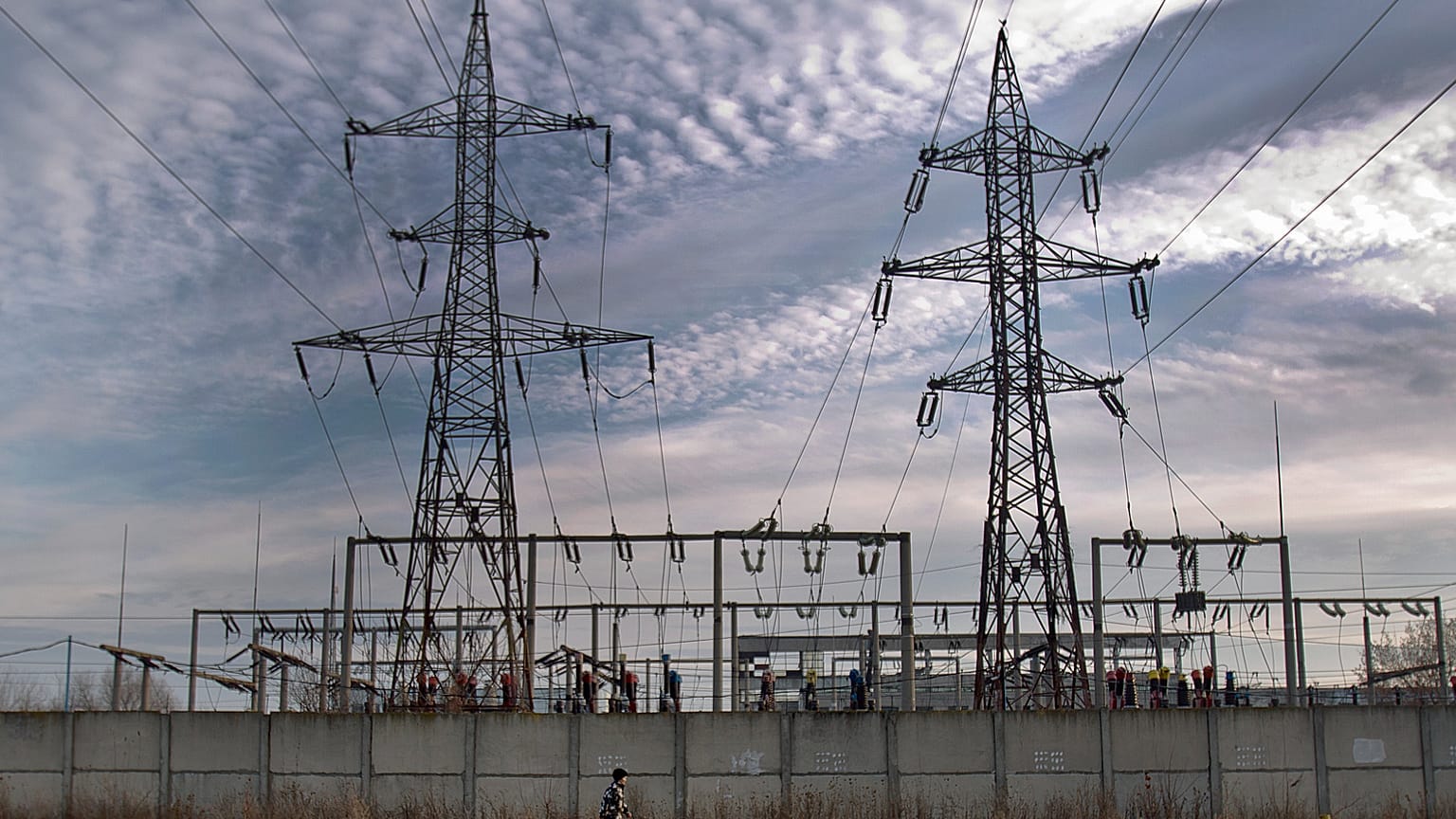 A woman walks by an electrical power distribution station in the Danube port city of Calarasi, southern Romania, Sunday, Dec. 11, 2011. 