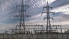 Una donna cammina accanto a una stazione di distribuzione dell'energia elettrica nella città portuale danubiana di Calarasi, nel sud della Romania, domenica 11 dicembre 2011. 