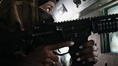 Un agente di polizia a bordo di un veicolo blindato pattuglia una zona di Port-au-Prince controllata da una gang, 19 gennaio 2026