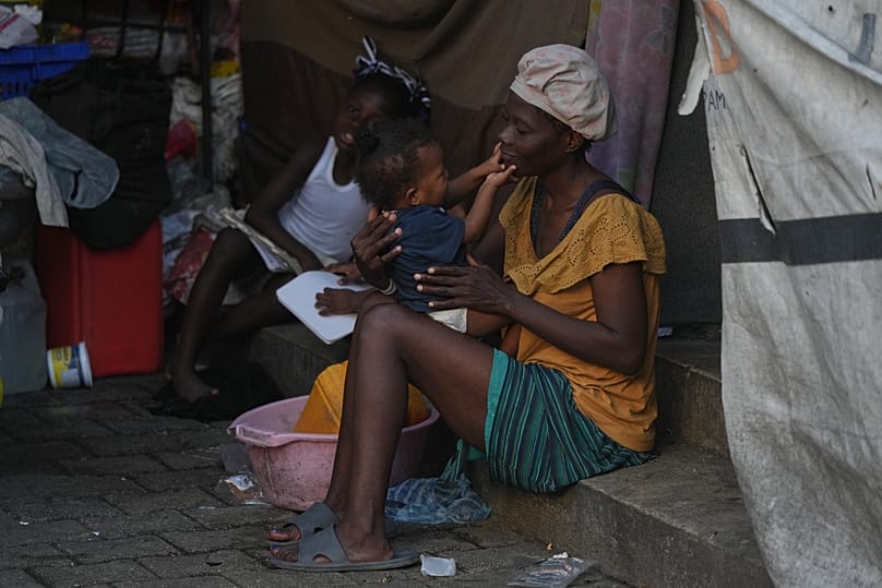 A woman holds her child at a shelter for families displaced by gang violence in Port-au-Prince, 27 January, 2026
