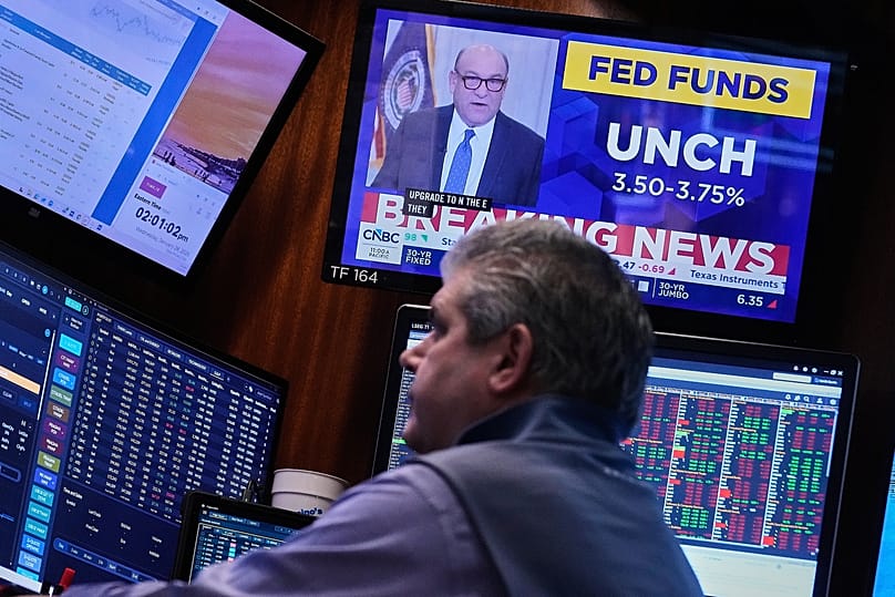 A screen above a trader displays the Federal Reserve rate decision on the floor of the New York Stock Exchange, 28 January, 2026