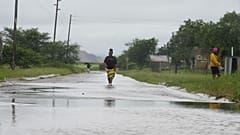 Am Freitag, 16. Januar 2026, waten Menschen in Nkomazi, Provinz Mpumalanga, Südafrika, durch Hochwasser.