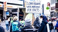 A protestor holding a sign reading "I can't believe we're marching for facts". 