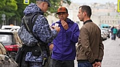 Военнослужащий Нацгвардии России проверяет документы, подтверждающие место жительства, во время рейда возле рынка "Апраксин Двор" в Санкт-Петербурге, Россия, 4 июля 2025 года.