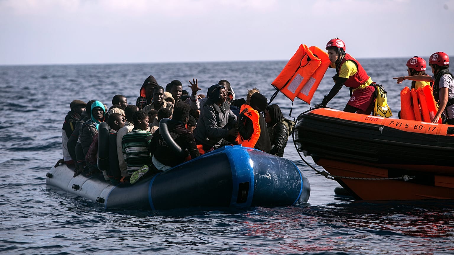 Los migrantes reciben chalecos después de que una ONG española los avistara y rescatara en el mar de Alborán, a 64 kilómetros de las costas españolas, el 11 de octubre de 2018