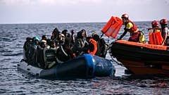 Los migrantes reciben chalecos después de que una ONG española los avistara y rescatara en el mar de Alborán, a 64 kilómetros de las costas españolas, el 11 de octubre de 2018