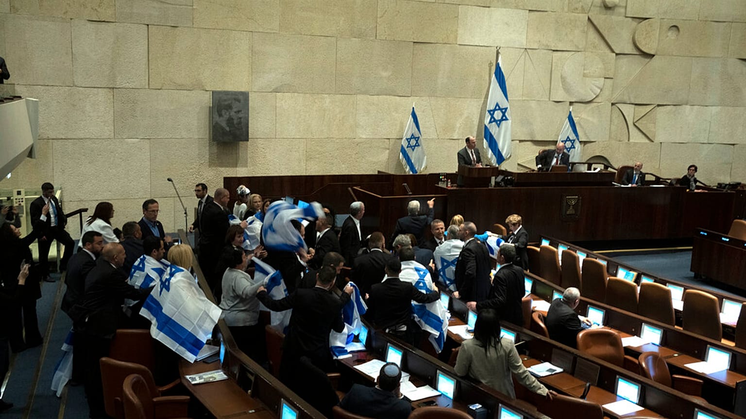 لفّ مشرّعون إسرائيليون أنفسهم بالعلم الوطني احتجاجاً داخل البرلمان الإسرائيلي (الكنيست