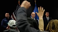 Members of the media raise their hands to ask questions as White House border czar Tom Homan holds a news conference in Minneapolis, 29 January 2026