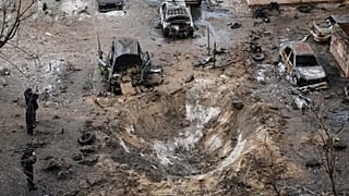 People stand near a crater and damaged cars after a Russian attack in Zaporizhzhia, 28 January, 2026