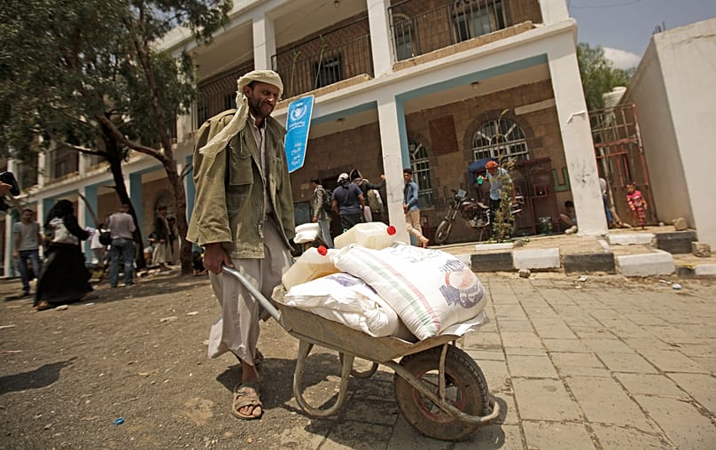 A displaced Yemeni receives food aid provided by the World Food Programme in Sana’a, 25 August, 2019