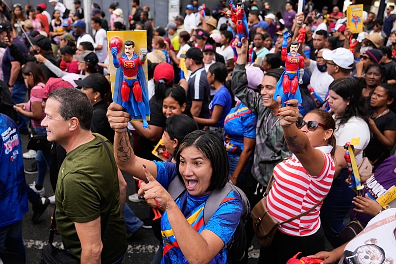 A government supporter holds an action figure of Nicolás Maduro during a protest demanding his release in Caracas, 4 January, 2026