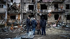 Menschen betrachten die Schäden nach einem Raketenangriff in der Stadt Kiew, 25. Februar 2022