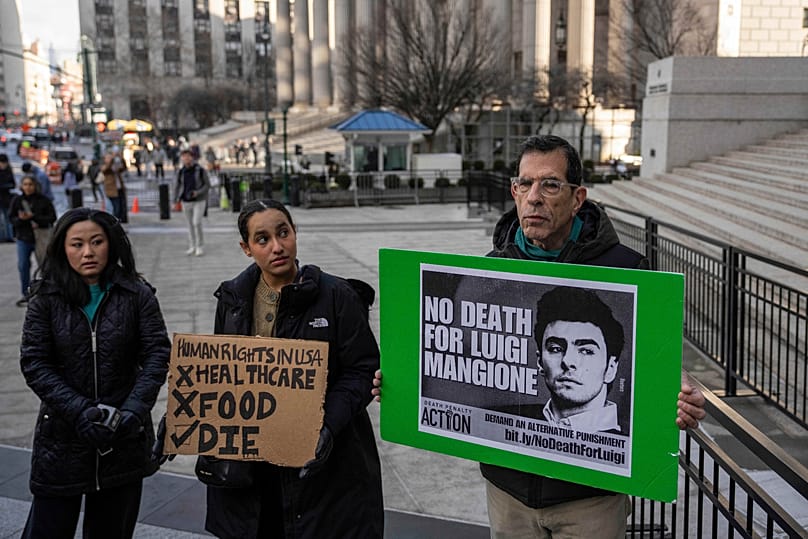 Supporters of Luigi Mangione hold signs outside Manhattan federal court, 9 January, 2026