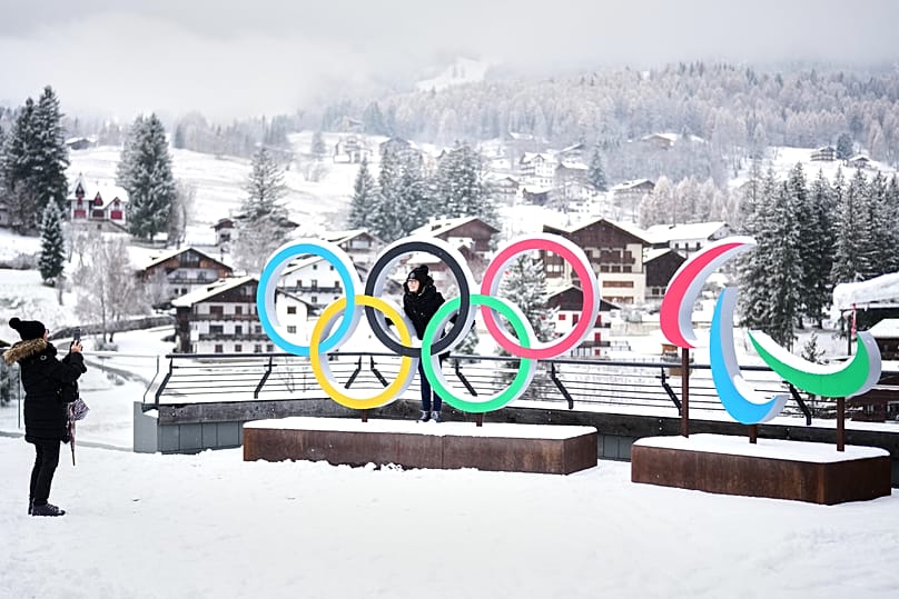  People take photos in front of the Milan Cortina Winter Olympics and Paralympics rings, in Cortina D'Ampezzo, Thursday, Nov. 20, 2025.