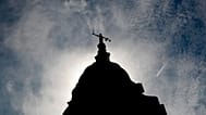 A statue of liberty is silhouetted as it stands atop the Old Bailey in London, 8 August, 2019