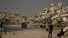 فلسطينيون يسيرون وسط الأنقاض التي خلفها الهجوم الجوي والبري الإسرائيلي في الزهراء وسط قطاع غزة، الأربعاء 28 يناير 2026. 