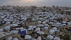 يسير أشخاص بين خيام تؤوي نازحين فلسطينيين وسط الدمار الذي خلّفته الهجمات الجوية والبرية الإسرائيلية في مدينة غزة، الأربعاء 28 يناير/كانون الثاني 2026. (أسوشيتد برس/جهد الشرفي)