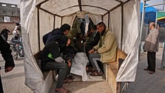 Palästinenser trauern um den Leichnam eines Menschen, der bei einem israelischen Angriff getötet wurde. Sie sitzen während der Beerdigung auf einem Wagen vor dem Al-Aqsa-Krankenhaus in Deir al-Balah.