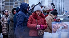 Menschen, die nach den russischen Luftangriffen ohne Strom sind, warten in einem Wohnviertel in Kiew, Ukraine, am Freitag, 30. Januar 2026, auf kostenlose warme Mahlzeiten.