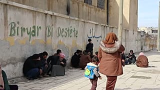 نازحون أكراد في كوباني، يجلسون قرب المدارس التي تحوّلت إلى مراكز إيواء.