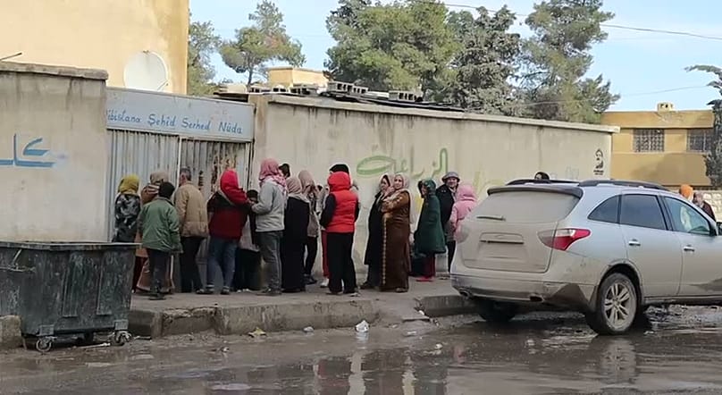 نازحون أكراد ينتظرون أمام أحد مراكز الإيواء بعد نزوحهم من مناطقهم