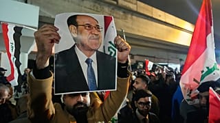 رجل عراقي يحمل صورة رئيس الوزراء السابق نوري المالكي، خلال احتجاج على جسر يؤدي إلى المنطقة الخضراء المحصنة حيث تقع السفارة الأمريكية في بغداد، العراق، الخميس 29 يناير 2026. 