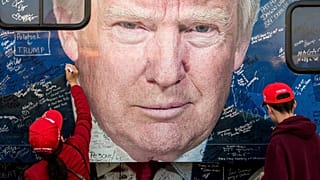 حامیان دونالد ترامپ پیش از گردهمایی انتخاباتی در پنسیلوانیا، در تاریخ ۵ اکتبر ۲۰۲۴، در حال امضای یک اتوبوس ستاد انتخاباتی