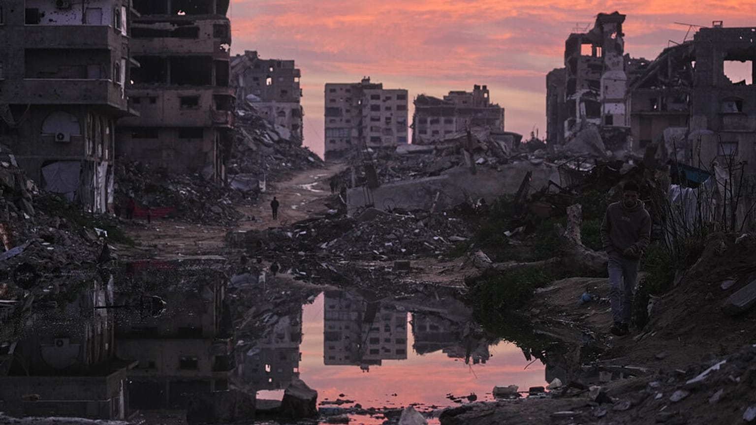 فلسطينيون يسيرون وسط مبانٍ دمّرتها الغارات الجوية والعمليات البرية الإسرائيلية في مدينة غزة، الخميس 29 يناير/كانون الثاني 2026. (صورة: جيهاد الأشرفي/أسوشيتد برس)