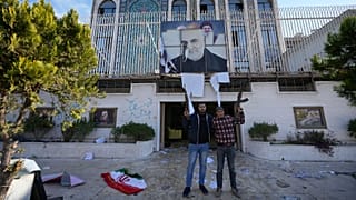 Syrian opposition fighters stand at the damaged entrance of the Iranian embassy in Damascus, Syria